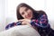 Delighted girl leaning on sofa while posing at camera