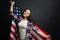 Delighted Hispanic American woman holding national flag indoors