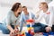 Delighted joyful family playing with construction blocks