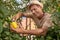 Delighted male in straw hat gathering lemons in the garden