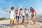 Delighted overjoyed friends standing on the beach