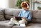 Delighted redhead boy with tablet sitting on sofa