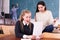 Delighted schoolgirl and Chinese girl schoolmate reading notification