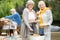 Delighted senior girlfriends with drinks and plates of food