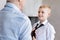 Delighted skillful gentleman knotting a tie