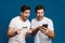 Delighted two guys posing with credit card and mobile phone