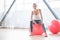 Delighted well built woman sitting on a pink fitness ball