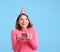 Delighted woman with cupcake making birthday wish
