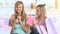 Delighted woman giving her girlfriend a present sitting between shopping bags