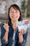 delighted woman holding keys and house made from banknotes