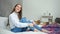 Delighted young pretty barefoot woman laughing sitting on bed in bedroom enjoying weekend