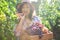 Delightful curly haired beautiful woman, vine grower tasting grapes while harvesting in vineyard on autumn early morning