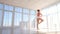 Delightful female ballet dancer in pink tutu practicing and smiling