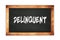 DELINQUENT text written on wooden frame school blackboard