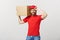 Deliver Concept: Young caucasian handsome delivery man holding a box on shoulder. Isolated over grey background.