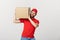 Deliver Concept: Young caucasian handsome delivery man holding a box on shoulder. Isolated over grey background.