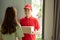 Deliver man in red uniform handing a parcel box over to a customer in front of the house