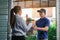 Delivery of an asian man handling a bag of food to a female customer at the door