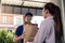 Delivery of an asian man handling a bag of food to a female customer at the door