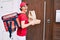 Delivery business worker woman wearing uniform smiling happy knocking on the door