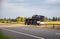 Delivery of cars on a cargo transporter along the highway in the summer. Business in the delivery and sale of cars