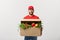 Delivery Concept: Handsome Caucasian grocery delivery courier man in red uniform with grocery box with fresh fruit and