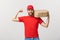 Delivery Concept - Portrait of Strong handsome delivery man flexing his muscle and holding pizza box packages. Isolated