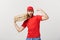 Delivery Concept - Portrait of Strong handsome delivery man flexing his muscle and holding pizza box packages. Isolated