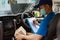 Delivery courier young man driver inside the van car with parcel post boxes checking amount