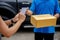 Delivery driver driving van with parcels on seat outside warehouse