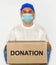 Delivery employee delivering cardboard box in medical gloves and mask.?oncept of safety mail goods courier delivery in virus or