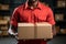 A delivery employee at a logistics warehouse holds a cardboard box