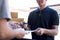 Delivery mail man giving parcel box to recipient and signature form, Young owner signing receipt of delivery package from post