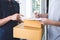 Delivery mail man giving parcel box to recipient and signature form, Young owner signing receipt of delivery package from post