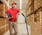 Delivery male worker with cardboard boxes on hand truck