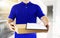 Delivery man in blue uniform and holding blank clipping board wi