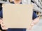 Delivery man in blue uniform holding the box on warehouse blurred Background