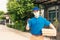 Delivery man courier sending and holding fast food pizza boxed in uniform he protective face mask show thumb up