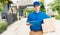 Delivery man courier in uniform hold parcel post boxes service shipment and walking finding and looking for customer home