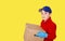 Delivery man employee in blue cap in gloves hold empty cardboard box