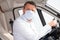 Delivery man in handmade medical mask in car during coronavirus, disease infection quarantine of covid-19