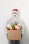 Delivery man holding cardboard box with gifts on white background. Christmas safe delivery. Donation concept