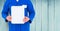 Delivery man holding clipboard against wooden background