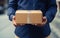 Delivery man holding a parcel in his hands. Close up of a delivery man holding a box