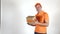Delivery man in orange uniform tossing a small parcel. Light gray backround, Super slow motion studio shot