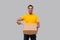 Delivery Man Pointing at Three Pizza Box in Hands Isolated. Yellow Tshirt Indian Delivery Boy. Man With Pizza in Hands