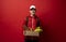 Delivery man in red uniform holds cardboard paper box with food isolated on white background, studio portrait. Service