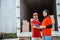 delivery man and smiling asian woman workers standing