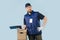 Delivery man in uniform holding signing form while leaning arm on a box