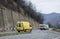 Delivery old yellow truck drives on a mountain road